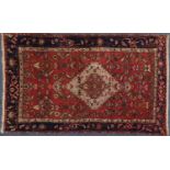 Rectangular Persian tribal rug having an all over stylised floral design onto red and midnight