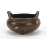 Chinese gold splashed patinated bronze tripod censer with twin handles, 6cm in diameter