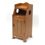 Art Nouveau oak night stand with stylised copper mounts, the hinged cupboard door inlaid with