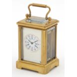 Miniature brass cased carriage clock with circular dial having Roman and Arabic numerals, 5.5cm high