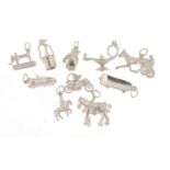 Ten silver charms including sewing machine, motorcycle, shire horse and skateboard, the largest 2.