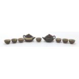 Chinese Yixing terracotta including a teapot and seven tea bowls with marbleised interiors, the