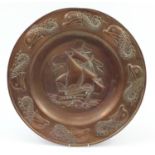 Newlyn school, large Arts & Crafts copper charger embossed with a stylised fish and a rigged ship,