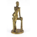 Bronze figurine of a female leaning on a console table, 23.5cm high