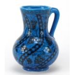 Islamic pottery vase with handle hand painted with stylised flowers, script to the base, 22cm high