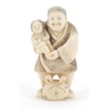 Japanese carved ivory netsuke of a man holding a child, character marks to the base, 6.5cm high
