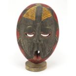 Large African tribal mask with applied metal mounts on display stand, 51cm high