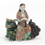 Chinese porcelain model of a female seated on a Shishi holding a sword, 25cm high