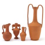 Four Roman style terracotta vessels including two vases with twin handles, 12.5cm high