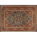 Rectangular Persian Hereke design rug decorated with stylised flowers onto midnight blue and red