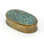 Antique oval brass snuff box having a hinged lid inlaid with turquoise, 9.5cm wide