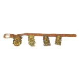 Leather belt housing four Chinese brass Emperor/Buddha heads, the largest head 16cm high