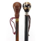 Two hardwood walking sticks with carved pommels, the largest 85cm in length