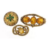 Three antique gilt metal brooches set with colourful stones, including a mourning brooch, the