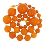 Amber coloured bead necklace, 60cm in length, the largest bead approximately 28mm in diameter, total