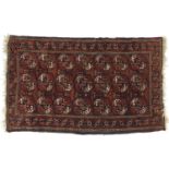 Rectangular Persian rug having repeat medallion design onto a red ground, 165cm x 101cm