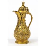 Turkish tombak copper wine jug embossed with stylised flowers, 18cm high