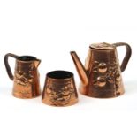 Newlyn, Arts & Crafts copper three piece tea set embossed with stylised fruit, comprising teapot,