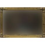 Arts & Crafts brass wall mirror with bevelled plate having applied ornate mounts, 94.5cm x 64cm