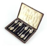 Set of six Art Nouveau silver plated teaspoons with sugar tongs, housed in a fitted tooled leather