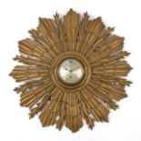 Vintage carved gilt wood sunburst design wall clock having a silvered dial having Arabic numerals,