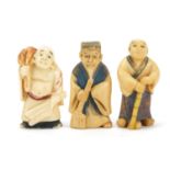 Three Japanese part stained carved ivory netsukes of elders, character marks to the bases, the