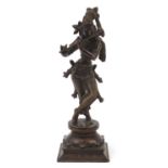 Indian patinated bronze figure of a Deity playing an instrument, 37.5cm high