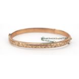 9ct gold hinged bangle, engraved with flowers, 6.8g