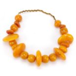 Large butterscotch amber coloured necklace, 70cm in length, the largest section 6.5cm in length,