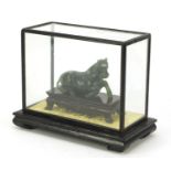Chinese jade style horse housed in a glazed case, 21cm wide