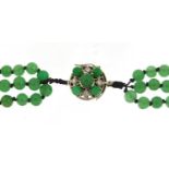 Chinese four strand green jade bead necklace with unmarked white metal diamond set clasp, 60cm in