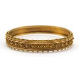 Victorian unmarked gold hinged bangle, (tests as 15ct gold) 6cm wide, 17.2g, housed in a T Wagner