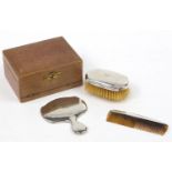 William Neale & Son Ltd, silver three piece vanity set housed in a velvet lined and tooled leather