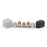 Five silver and white metal thimbles including one housed in a Victorian thimble case, the largest