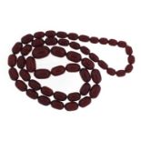 Cherry amber coloured bead necklace, 92cm in length, the largest bead 2.7cm in length, 115.0g