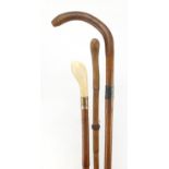 Three walking sticks including a bamboo example with ivory pommel, one with silver collar, the