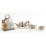 Mappin & Webb silver plated three piece tea service and a cruet stand with glass bottles, the