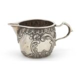 Silver milk jug with embossed decoration, indistinct hallmarks, 4.5cm high, 55.5g