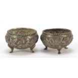 Pair of Burmese silver coloured metal open salts, embossed with animals and trees, 5cm in