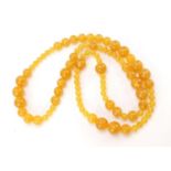 Amber coloured bead necklace, 110cm in length, the largest bead approximately 2cm in diameter, 152.