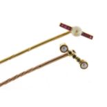 Two Art Deco unmarked gold tie pins set with rubies, pearls and emeralds, the largest 6.5cm in
