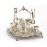 Victorian silver plated egg stand on four mask feet with glass liners and six spoons, impressed V