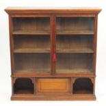 Walnut bookcase with a pair of glazed doors above a fall and open shelves, 132cm H x 129cm W x