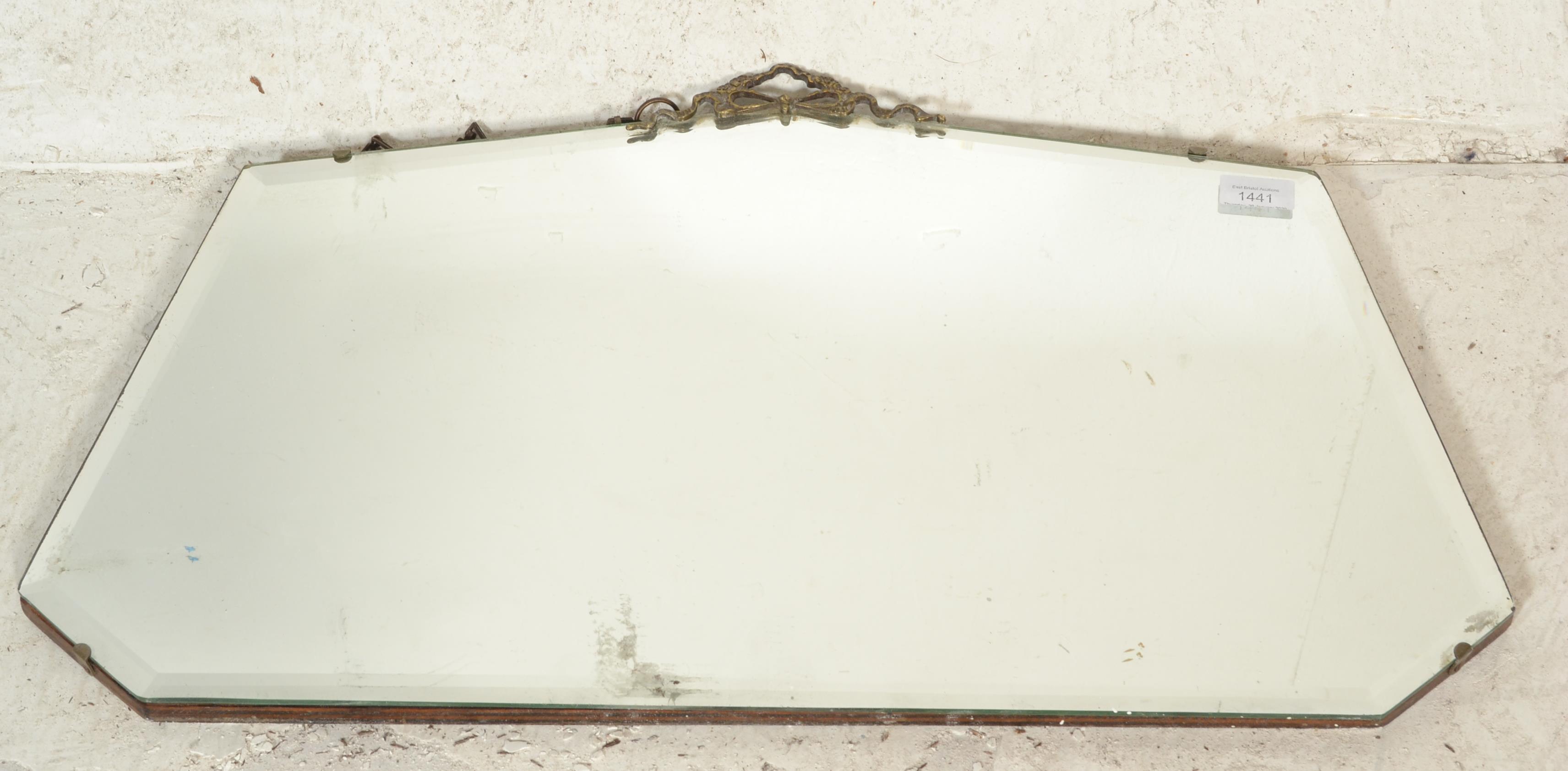 An early 20th Century frameless bevelled edged mirror having decorative brass swag moulded top and - Image 2 of 5