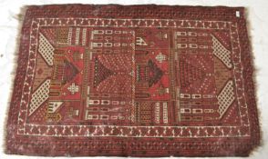 An early 20th Century Persian floor rug carpet on red ground, central medallion panel with buildings