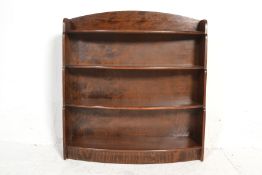 A vintage 20th Century mahogany waterfall bookcase having four bow front shelves raised on a