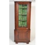 A 19th century mahogany freestanding corner cupboard, the moulded top above a glazed door