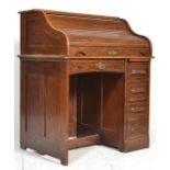 An early 20th Century oak tambour fronted roll top single pedestal desk, the roll top opening to