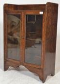 A 1940's oak bookcase cabinet having twin glass doors with gallery shelf above and central shelves
