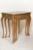 A 20th Century French Empire nest of three tables having french style pierced bowed gilt legs with